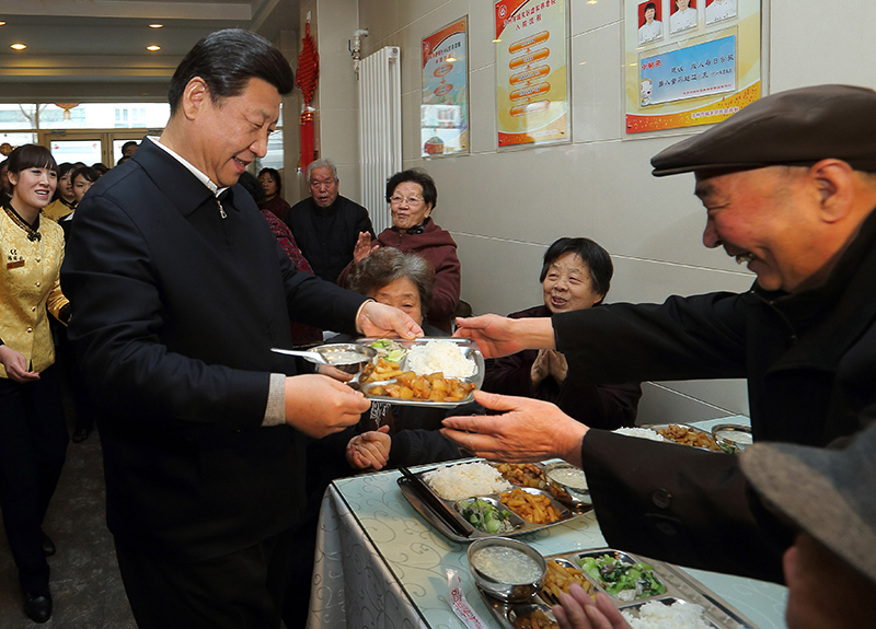 2013年2月4日，习近平总书记来到甘肃兰州一家养老餐厅，端起一盘热气腾腾的饭菜，送到一位老人面前。