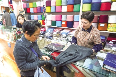 阿冬(右)向客户展示商品