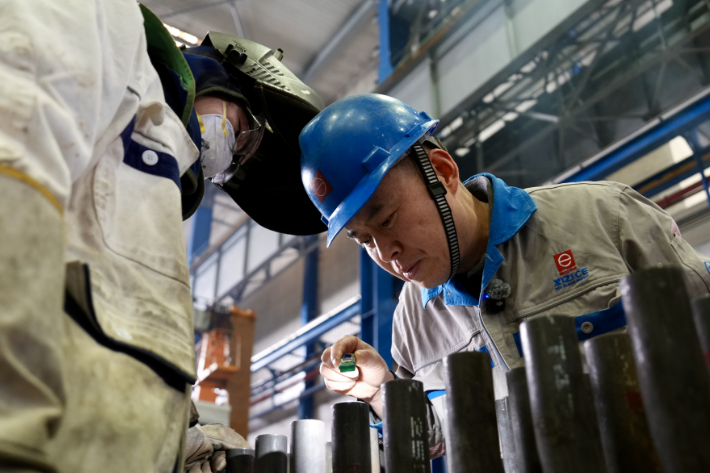 葛小青(右)检查徒弟的焊接成果,指导教学。周旭辉/摄 图片