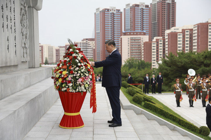 6月9日上午,正在朝鲜进行国事访问的中共中央总书记、国家主席习近平和夫人彭丽媛参谒中朝友谊塔。朝鲜劳动党总书记、国务委员长金正恩和夫人李雪主陪同。这是习近平整理花篮缎带。新华社记者 丁海涛 摄