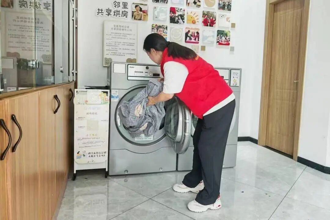 社区志愿者对物业管家收集的社区老人衣物进行清洗 图片