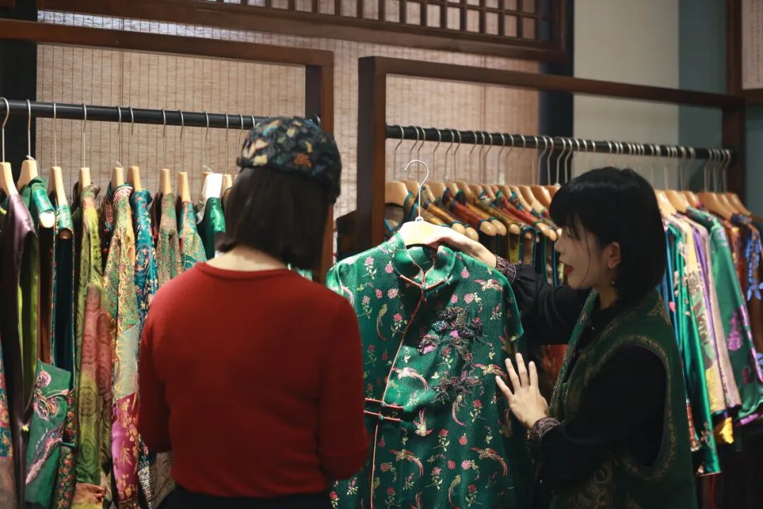店家为年轻消费者介绍新中式服装